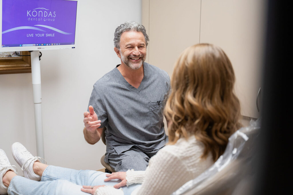 Dr. Kondas smiling with patient seated in dental chair